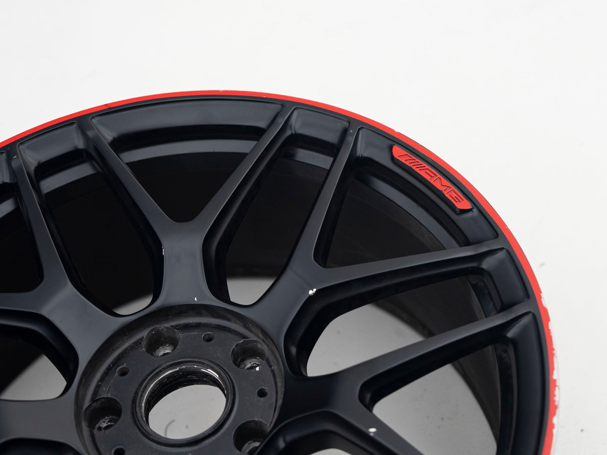 AMG 22-inch wheel, black face and red lip — actual stock photograph